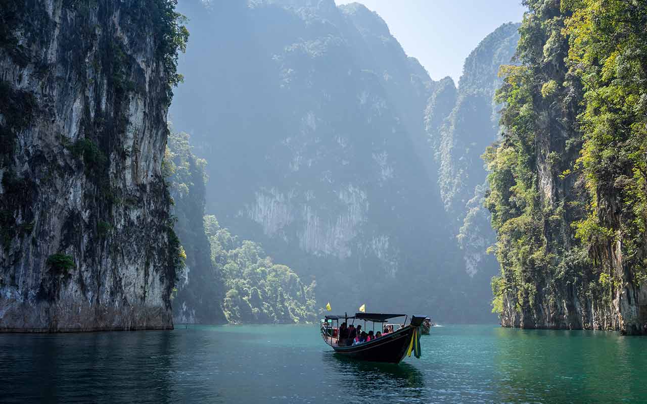  A boat filled with tourists in Cheow Lan Lake, Khao Sok National Park, Thailand