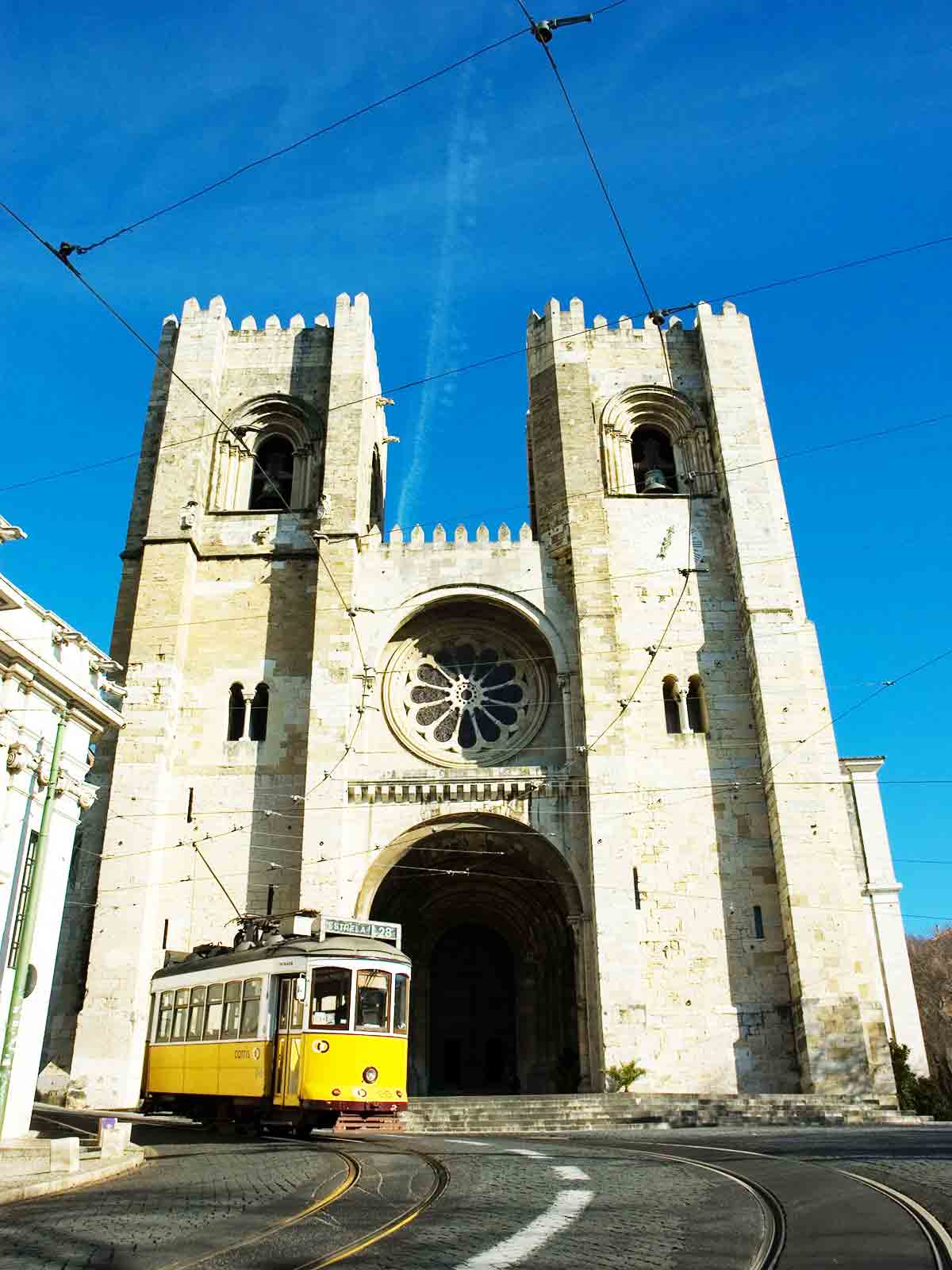 Trams pass by the Lisbon Cathedral