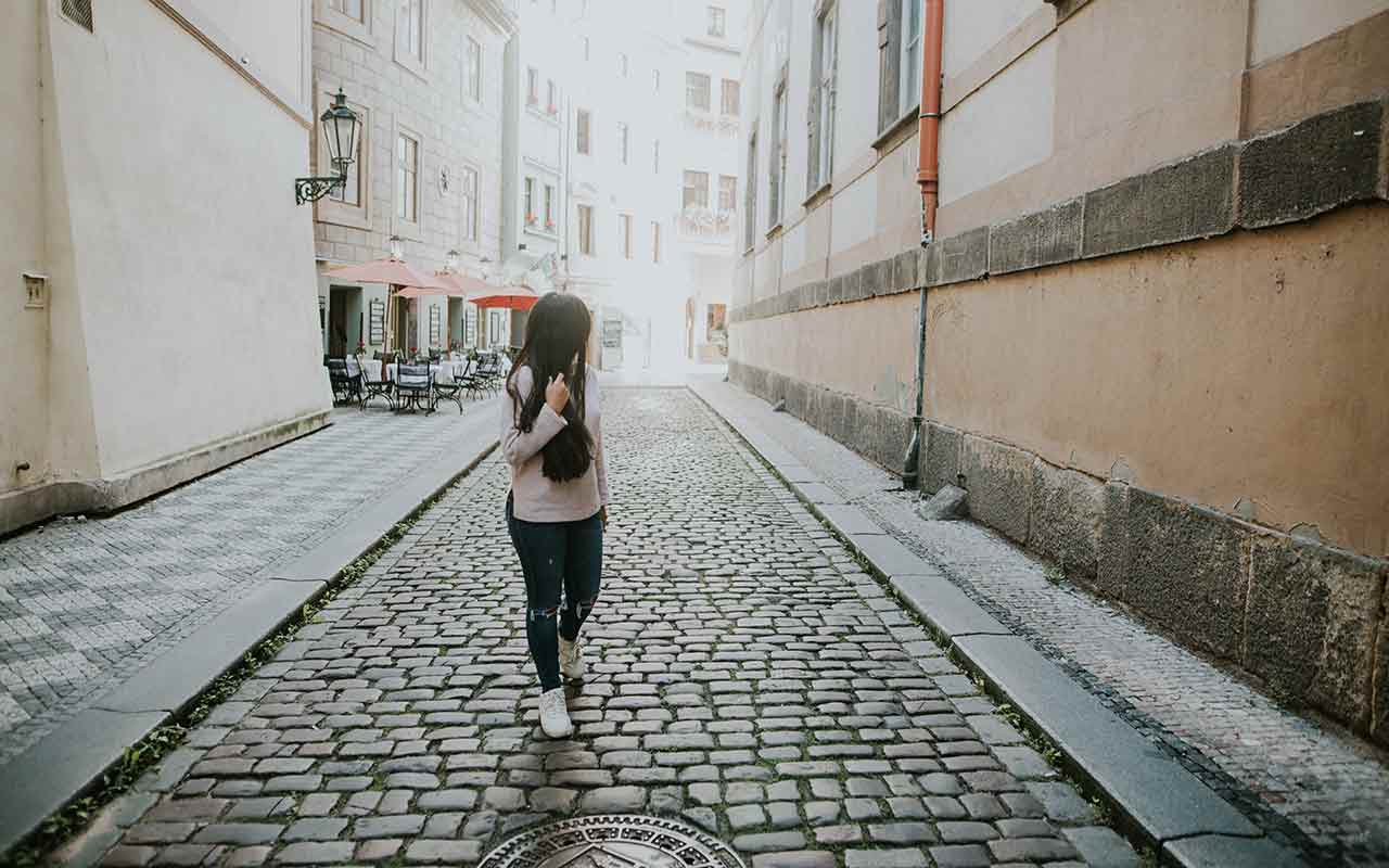A woman looking back as she walks up in a street in Prague