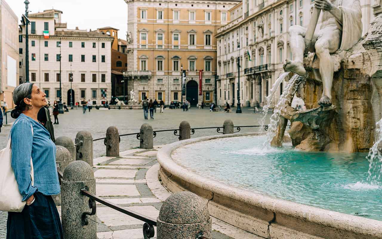 A tourist at Piazza Novana looking into the Fountain of Four Rivers