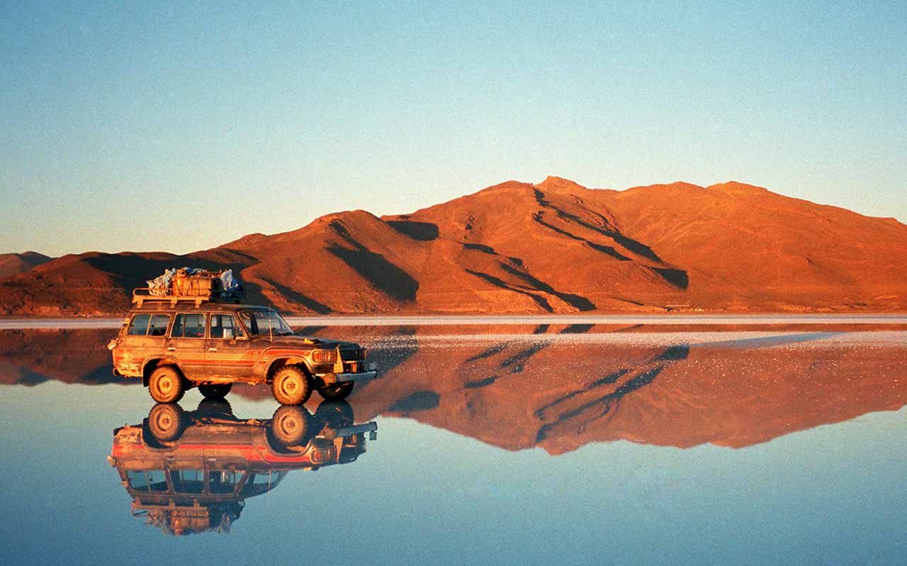 A car sitting on top with its reflection on the Uyuni Salt Flats 