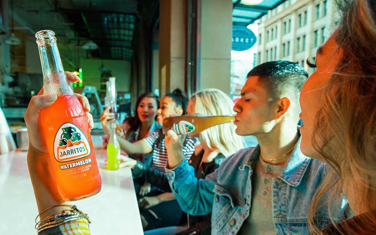 A tourist drinks Jarritos soda, originally sold in Mexico, at Central Market hangout in Los Angeles